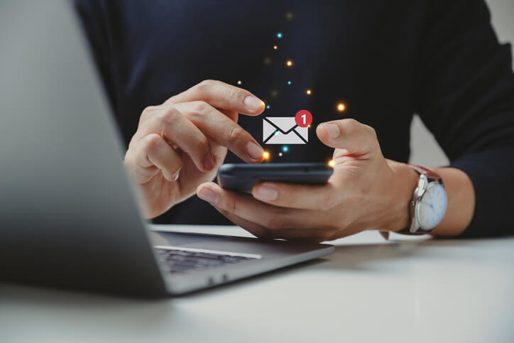 The hand of a digital marketer using a smartphone for email marketing during his digital marketing career