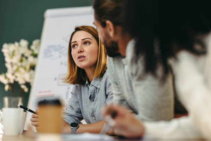 A digital marketing training graduate collaborating with colleagues in an office.