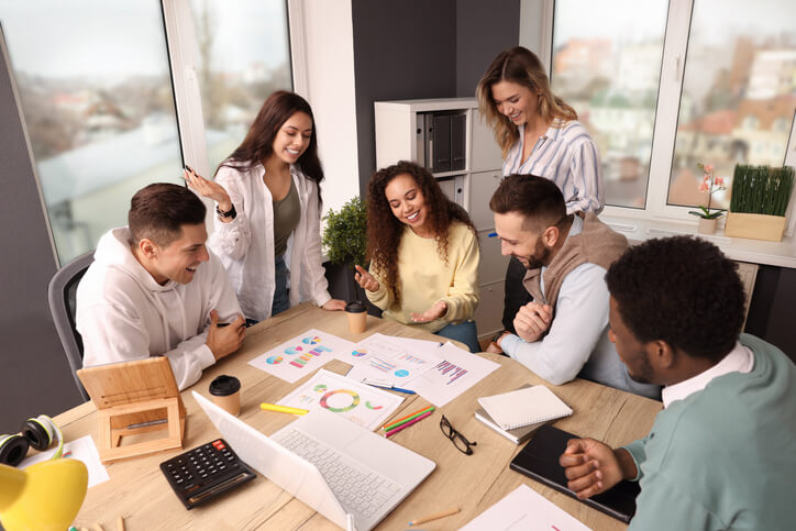 A team of marketing students discussing the importance of ethics in building consumer trust after completing their diploma in digital marketing