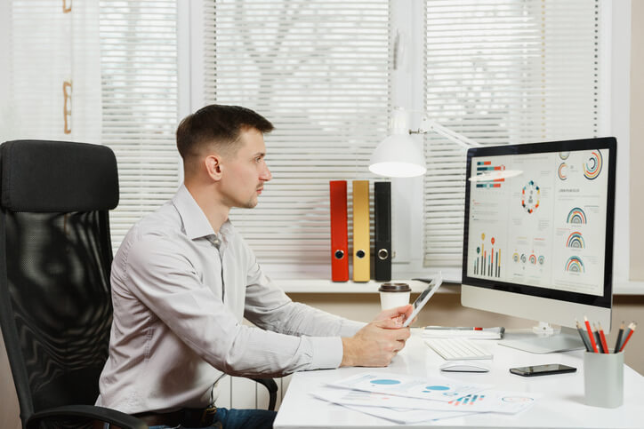 An aspiring marketer analyzing campaign metrics on a computer screen after completing his digital marketing diploma program.