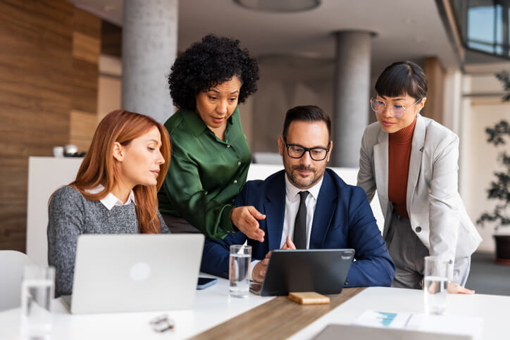 A web marketing team planning strategy together using digital devices in a collaborative workspace.