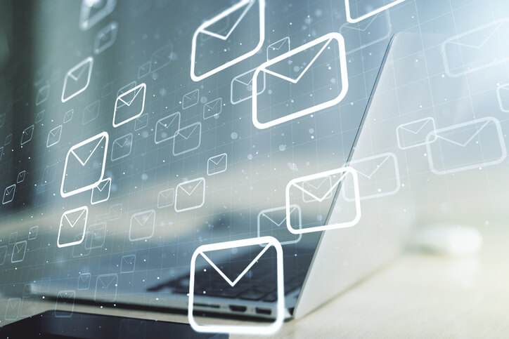 A laptop displays floating envelope icons in a digital overlay, symbolizing email communication. The concept illustrates email marketing, digital correspondence, messaging automation, and online communication strategies in a connected, technology-driven business environment.
