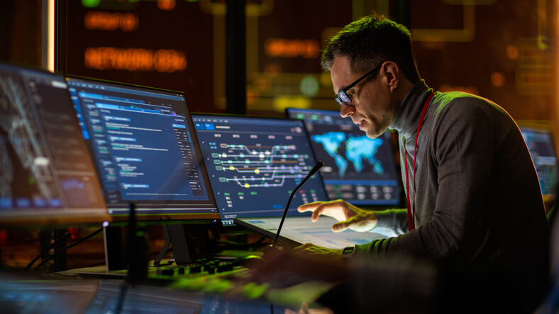 A SOC analyst monitoring cybersecurity alerts on multiple screens