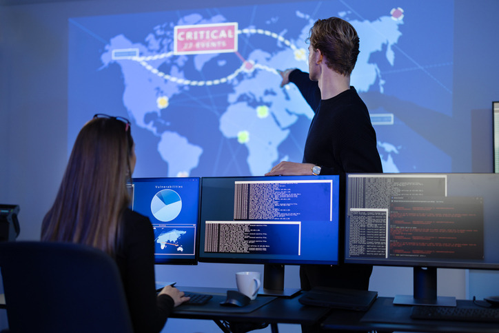 Analyste SOC surveillant des alertes de cybersécurité sur plusieurs écrans.