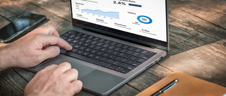 Digital marketing student reviewing GA4 website traffic reports on a laptop