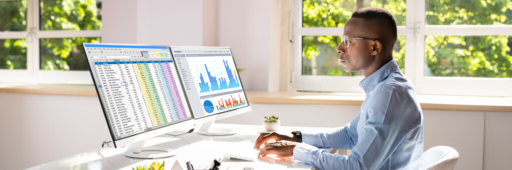 Data analyst reviewing sales trends and visual reports on a computer