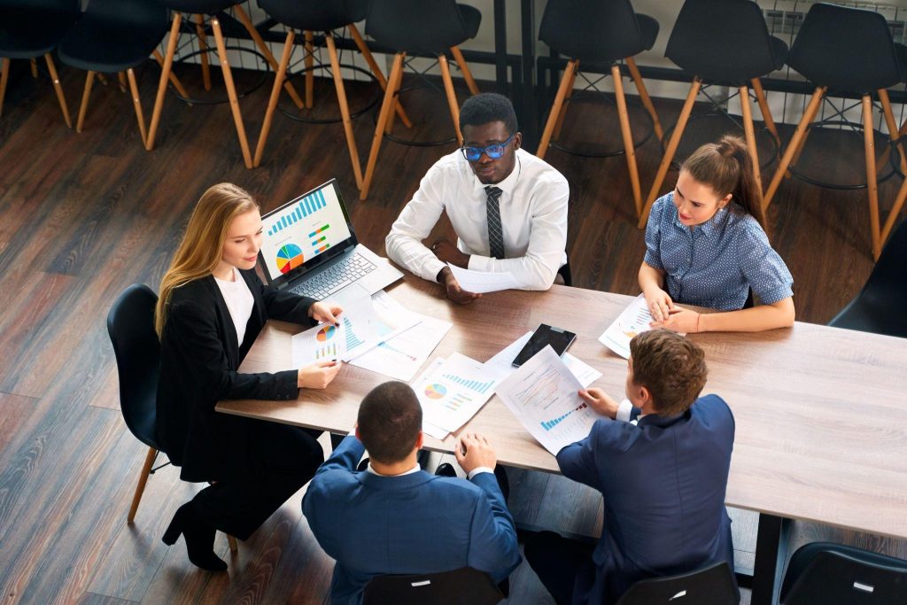 A team of business professionals discussing AI-generated insights during a team meeting